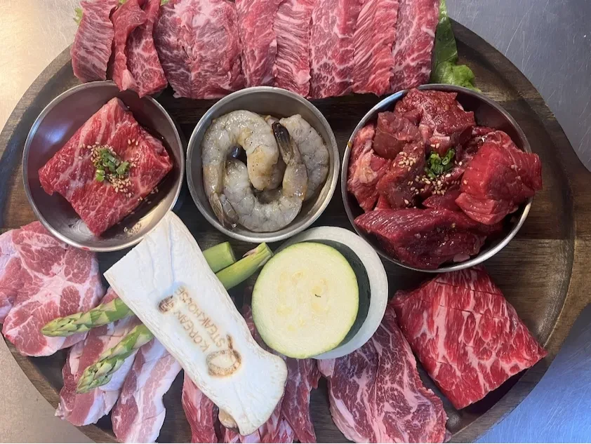 Q Korean Steakhouse meat and seafood platter on wooden board