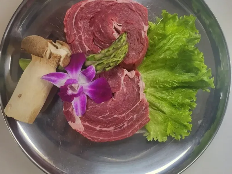 Beef filet with orchid garnish on silver plate