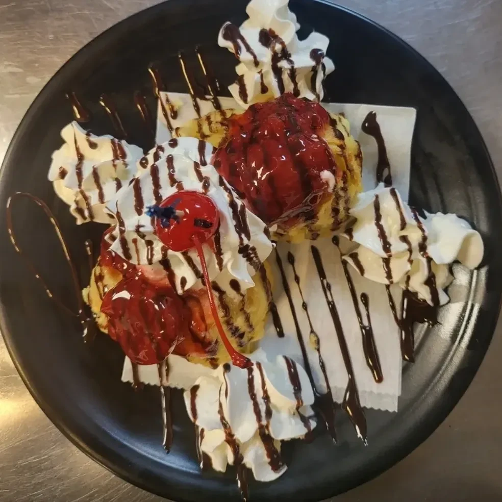 Fried ice cream dessert with whipped cream and chocolate drizzle