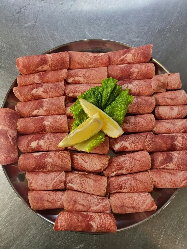 Rolled beef short rib platter with lemon garnish